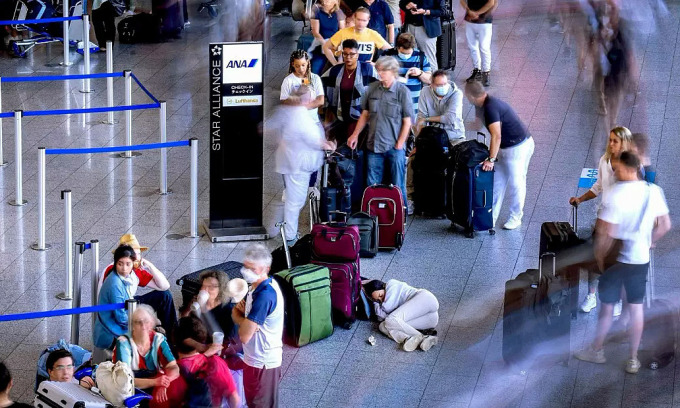 Du khách chờ đợi trong mỏi mệt ở sân bay quốc tế Frankfurt, Đức hồi đầu tháng. Ảnh: AP