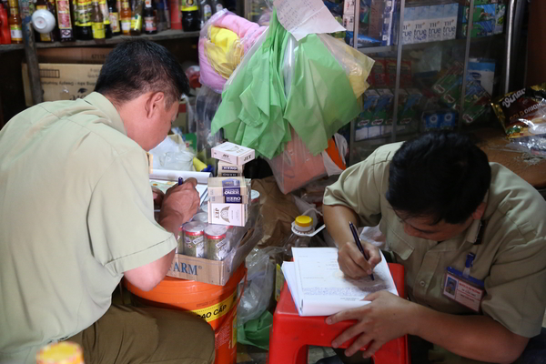 Lực lượng chức năng làm biên bản xử lí cửa hàng buôn bán thuốc lá điếu nhập lậu