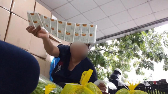 Công nhân dán tem của Nông sản Trình Nhi với nội dung "Rau củ quả Đà Lạt" chuẩn VietGAP lên rau từ chợ đầu mối - Ảnh: BÔNG MAI