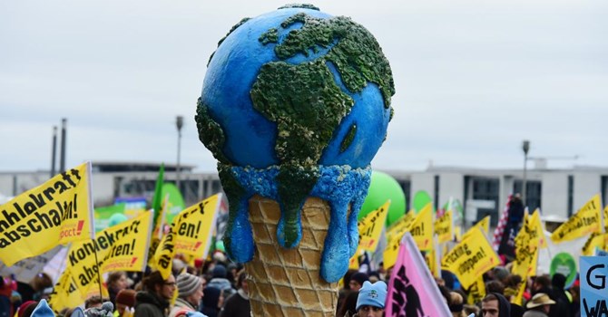 Người biểu tình tại Berlin dùng hình ảnh cây kem bị tan chảy để biểu tượng cho hiện tượng khí hậu ấm dần. Ảnh AFP PHOTO/JOHN MACDOUGALL