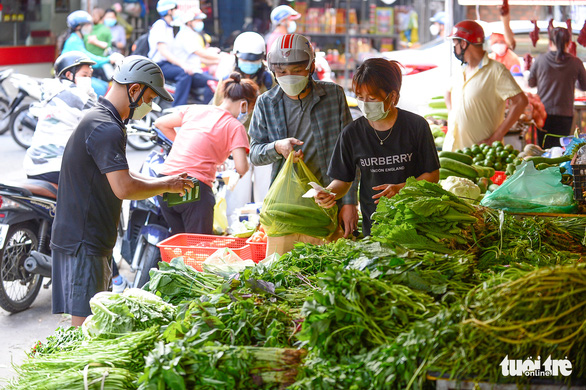 Người dân mua rau tại chợ Tân Sơn Nhất, quận Gò Vấp, TP.HCM - Ảnh: QUANG ĐỊNH