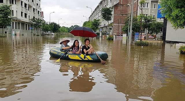 Cảnh người dân đi thuyền trong khu đô thị Geleximco sau cơn mưa lớn hồi năm 2018. (Ảnh PL.TPHCM)