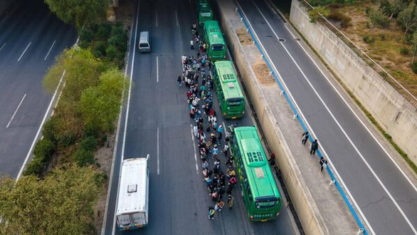 Nhân viên Foxconn bắt xe buýt đưa đón về nhà từ Trịnh Châu - Ảnh: BLOOMBERG