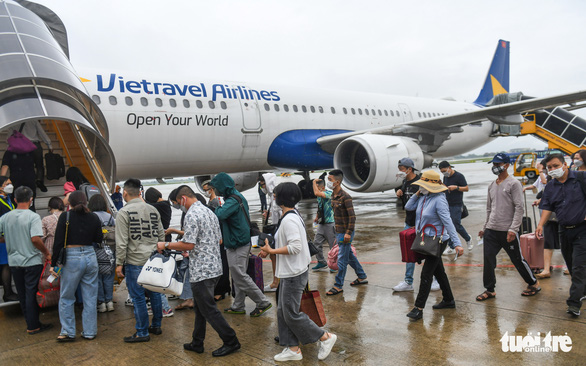 Hành khách lên máy bay tại sân bay Nội Bài (Hà Nội) để bay đến TP.HCM - Ảnh: QUANG ĐỊNH