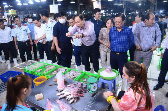 Bộ trưởng Lê Minh Hoan (thứ hai từ phải qua) kiểm tra chợ đầu mối Bình Điền (TP.HCM) vào rạng sáng 17-10 - Ảnh: Q.ĐỊNH