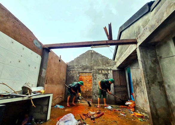 Bộ đội hỗ trợ người dân thôn Khánh Mỹ (xã Vinh Xuân, huyện Phú Vang, Thừa Thiên Huế) dọn dẹp nhà cửa sau bão - Ảnh: NHẬT LINH