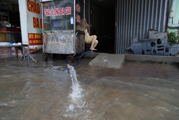 Tại một số nhà dân ở quận Ninh Kiều, máy bơm phải chạy hết công suất sáng 11-10 để bơm nước ngập trong nhà ra ngoài - Ảnh: CHÍ QUỐC